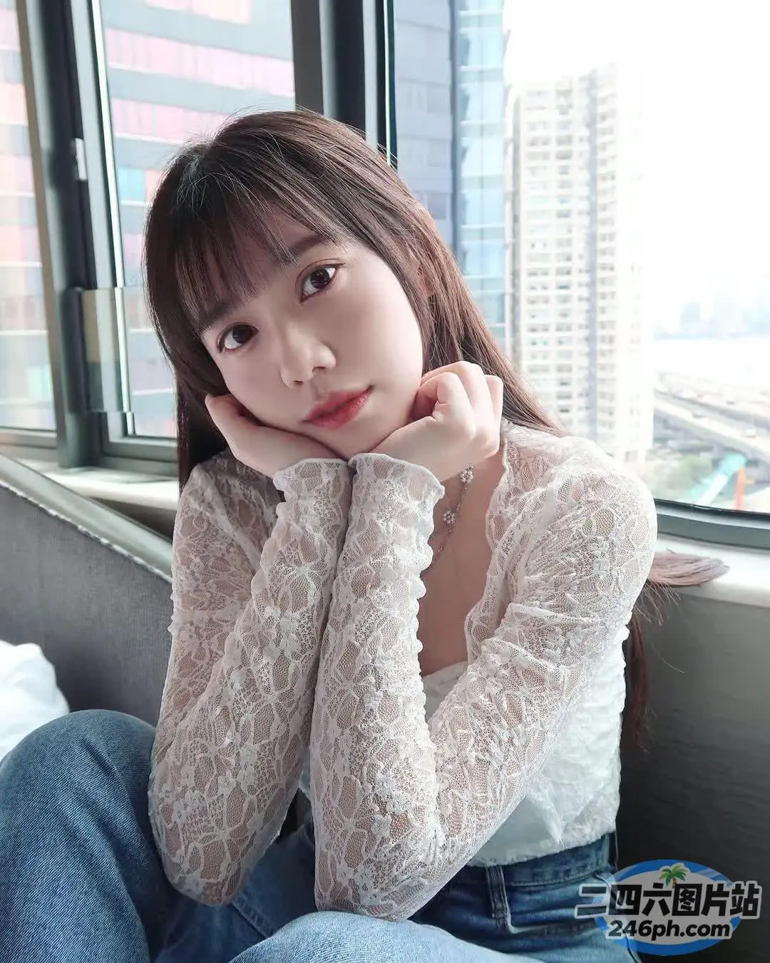 一个女人坐在靠近窗户的沙发上的特写