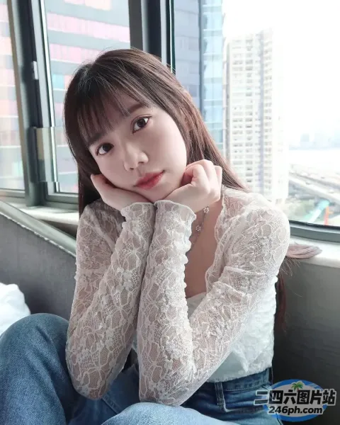 一个女人坐在靠近窗户的沙发上的特写