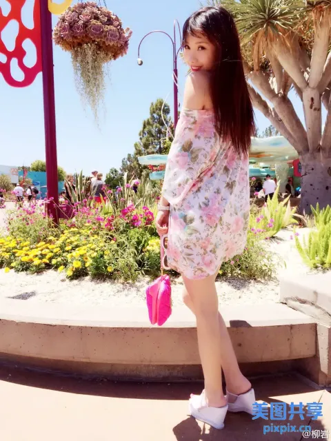 身着碎花裙的阿拉夫女人站在花园前
