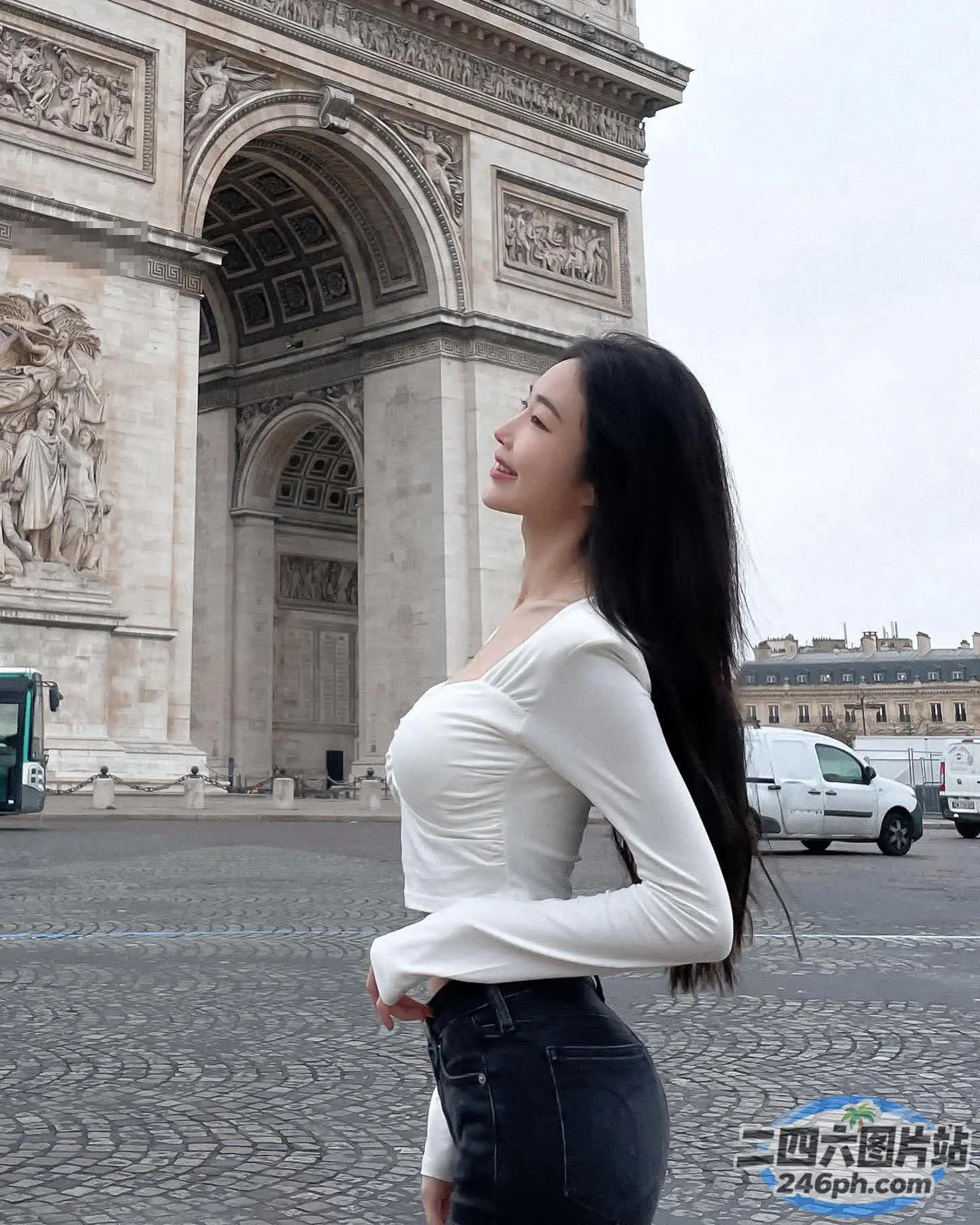 身穿白衬衫和黑色裙子的阿拉菲女子站在一栋建筑前