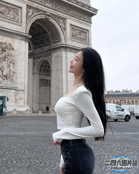 身穿白衬衫和黑色裙子的阿拉菲女子站在一栋建筑前