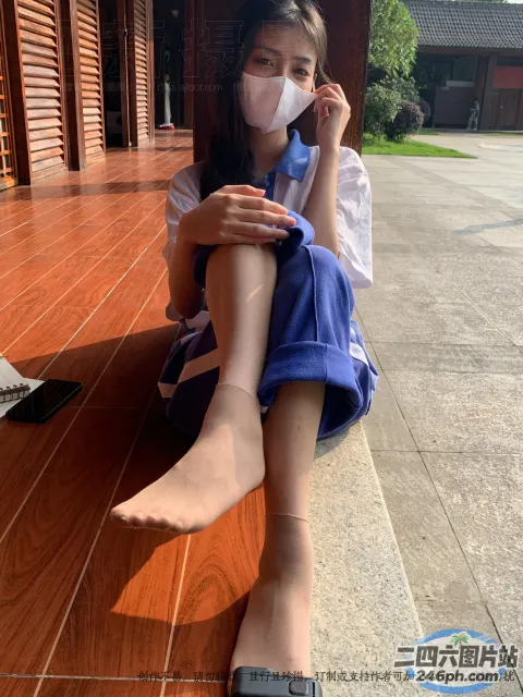 地板上坐着一个戴着口罩的女人