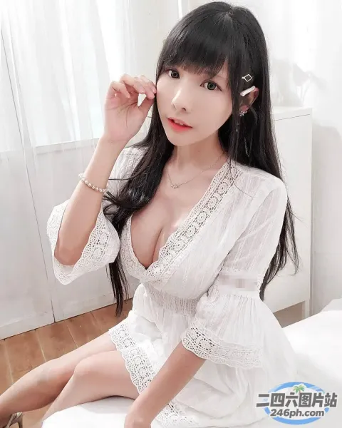 一个穿着白色连衣裙坐在床上的女人的特写