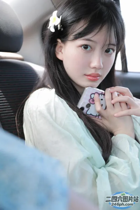 车里坐着一个年轻的女人，手里拿着一个遥控器