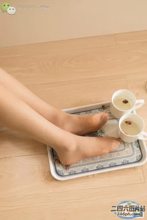 有一个女人坐在托盘上，端着两杯茶