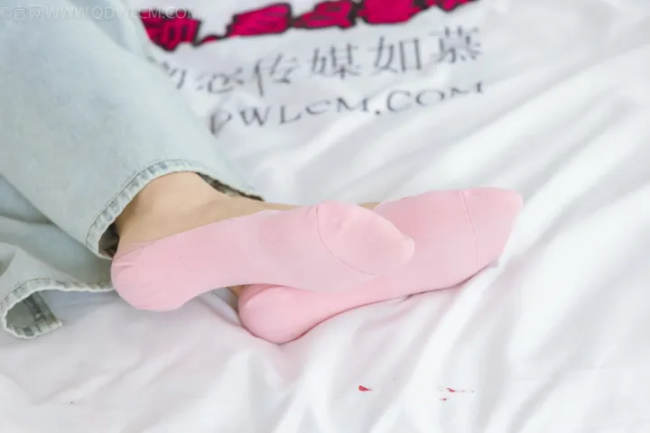 有人穿着粉红色的袜子躺在床上