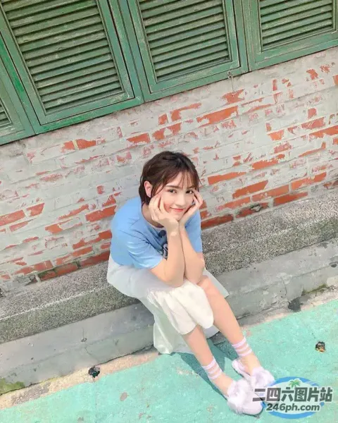 有一个女人坐在地上，手放在头上
