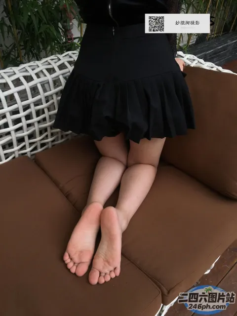 有一个女人坐在沙发上，双腿交叉