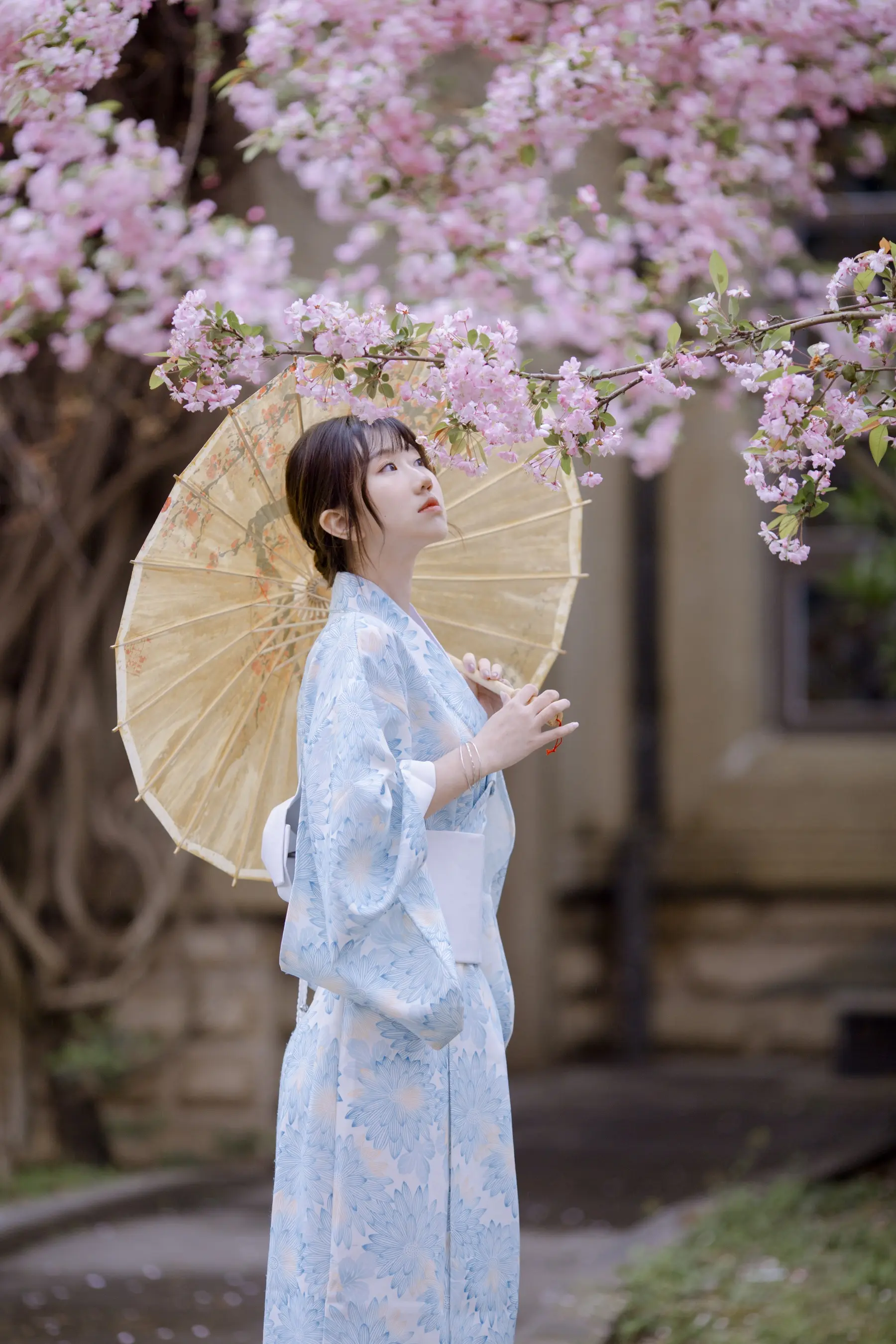 身穿蓝色和服，撑着黄色雨伞的 araffe 女子