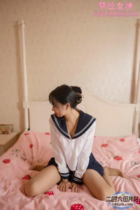 坐在床上的穿着水手服的 arafed 亚洲妇女