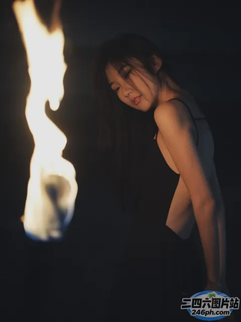 一个女人手里拿着一把火，看着它