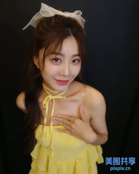 一名身穿黄色连衣裙的女子摆姿势拍照的特写