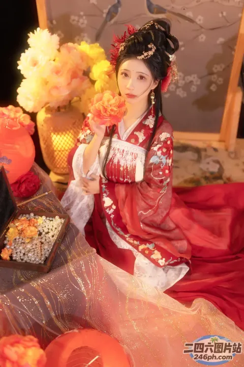 床上坐着一个穿着红色连衣裙的女人