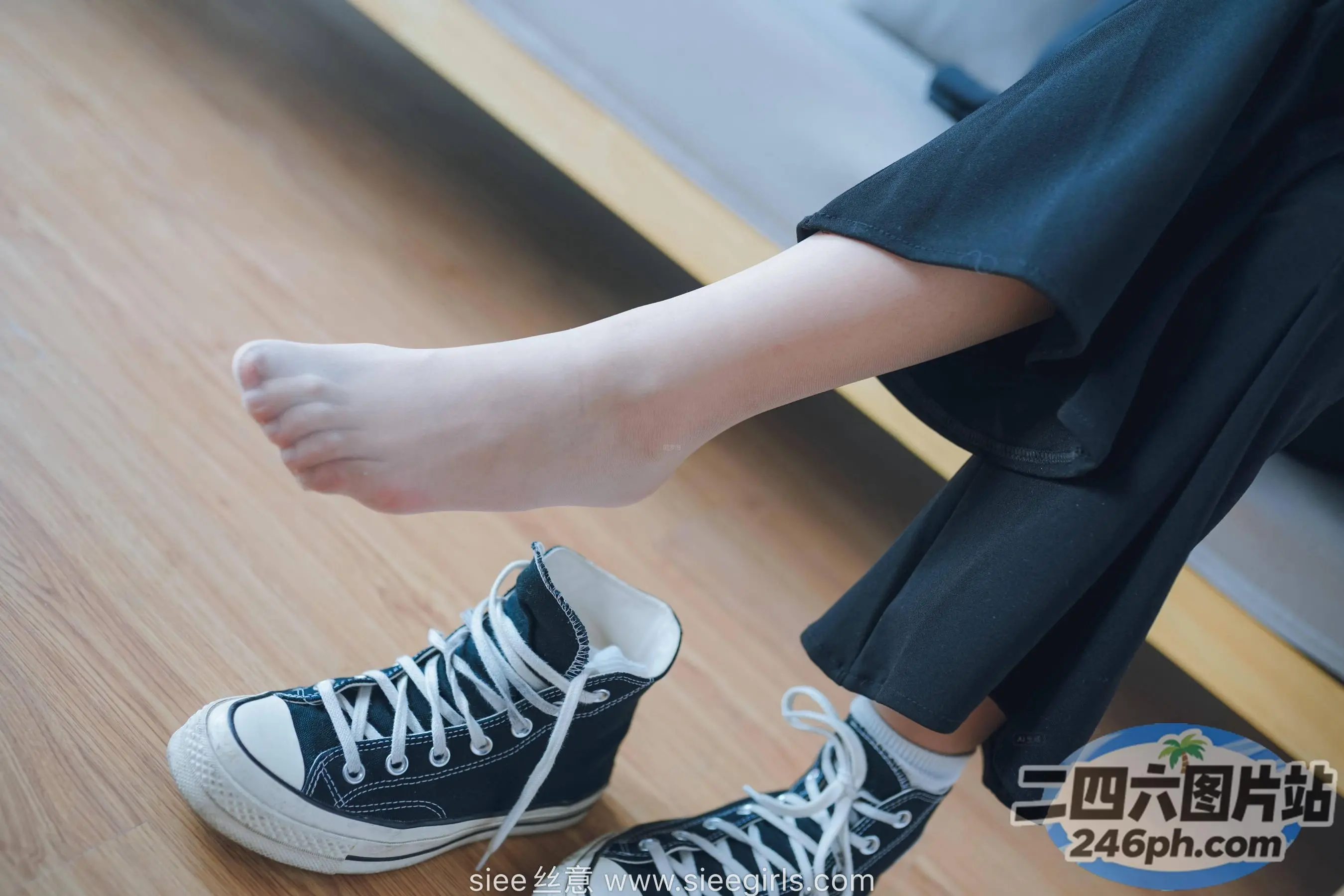 有人坐在沙发上，双脚抬起，穿着鞋子