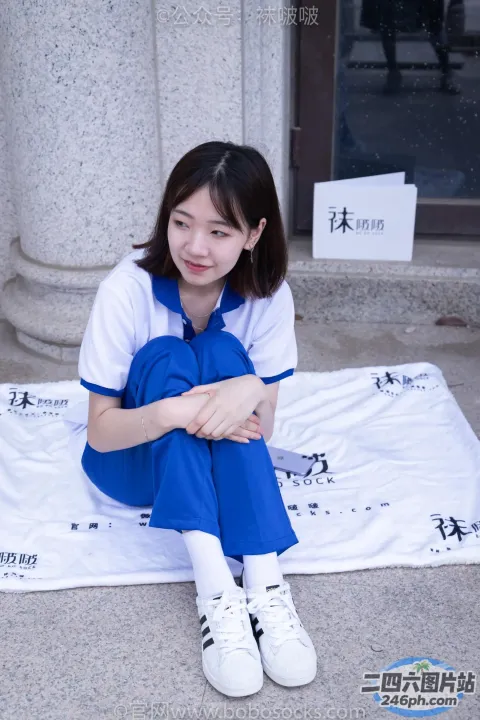 坐在建筑物前毯子上的阿拉菲德女人