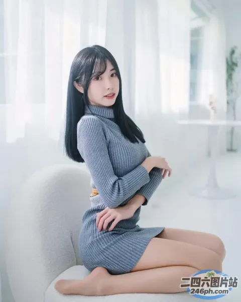 一个女人坐在一个房间里的沙发上，房间里有一把白色的椅子