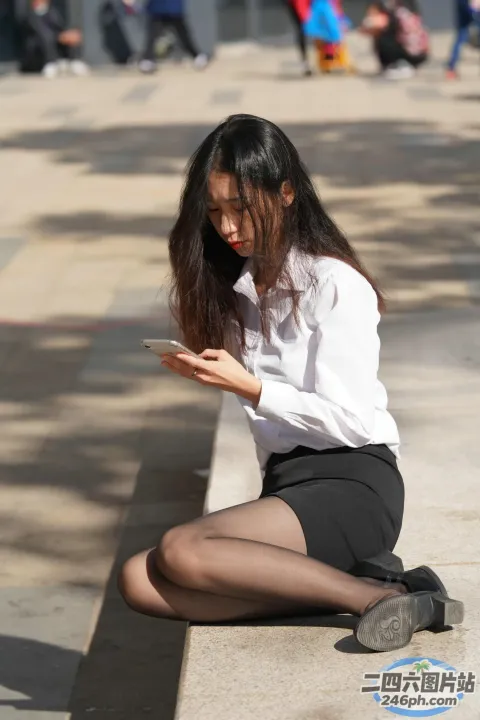 阿拉菲女子坐在地上用手机