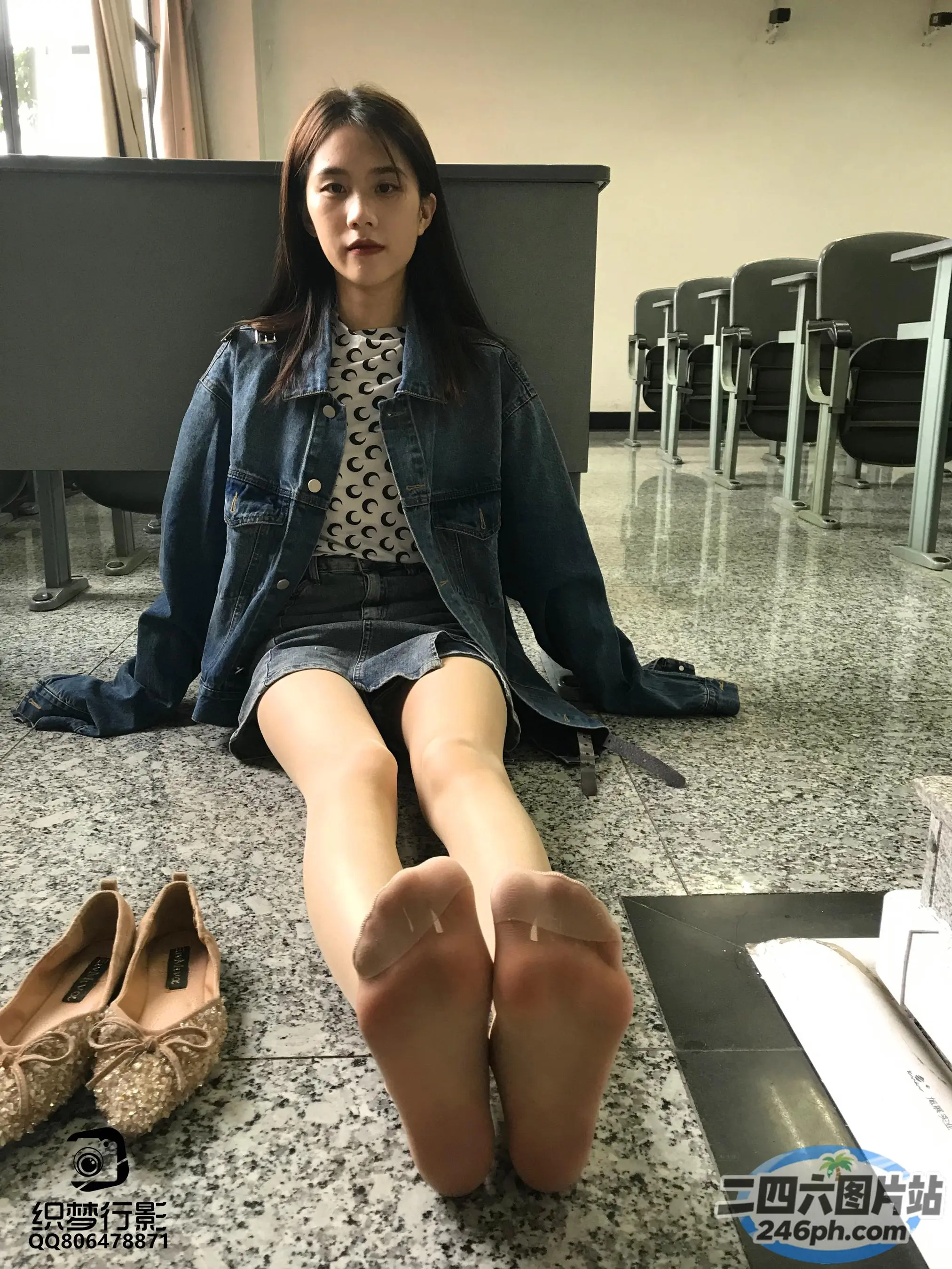 一个女人坐在地板上，双脚抬起，双叉