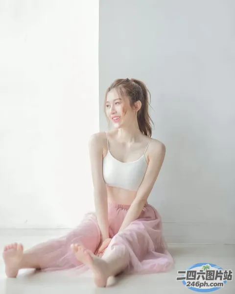 一位身穿粉红色芭蕾舞裙的女士坐在地板上