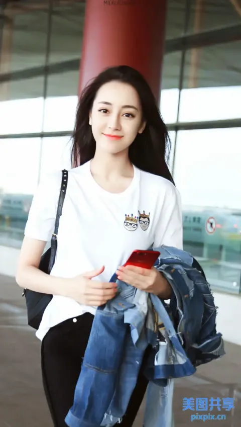 身穿白衬衫和黑裤子的阿拉夫女子拿着手机