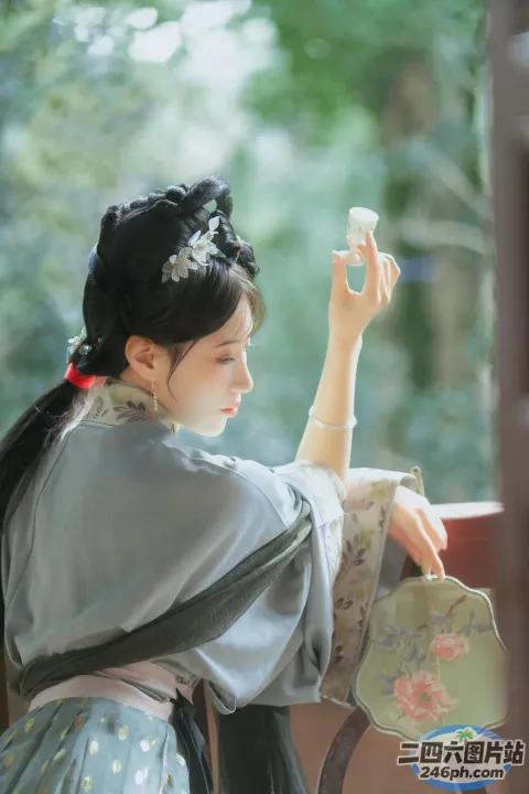 有一个女人手里拿着一个杯子