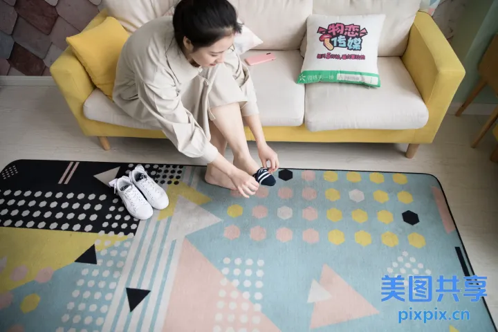 阿拉夫女人坐在沙发上，手里拿着相机