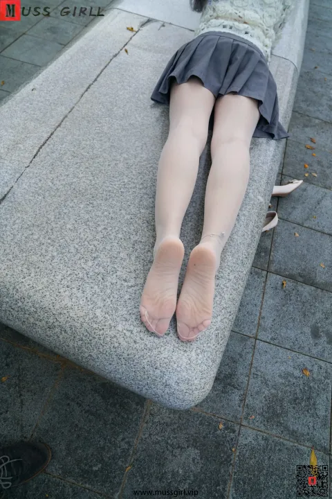 有个女人双腿交叉躺在长凳上