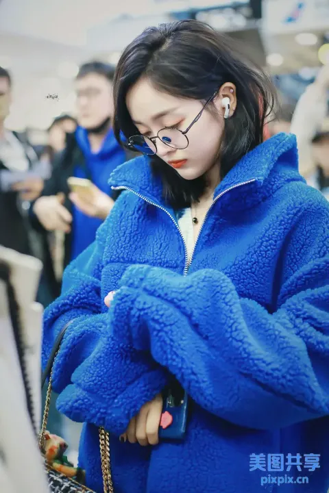 有个穿蓝色夹克的女人在看手机