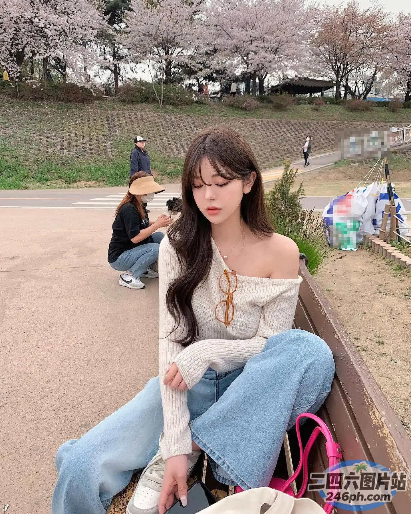有个女人拿着钱包坐在长凳上