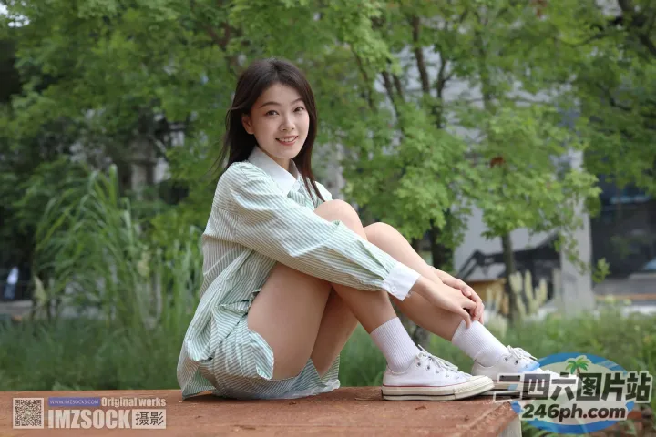 阿拉菲坐在公园的长椅上，手里拿着一本书