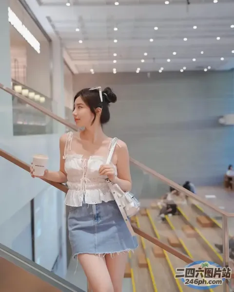 一个穿着白色上衣和蓝色裙子的女人走下楼梯