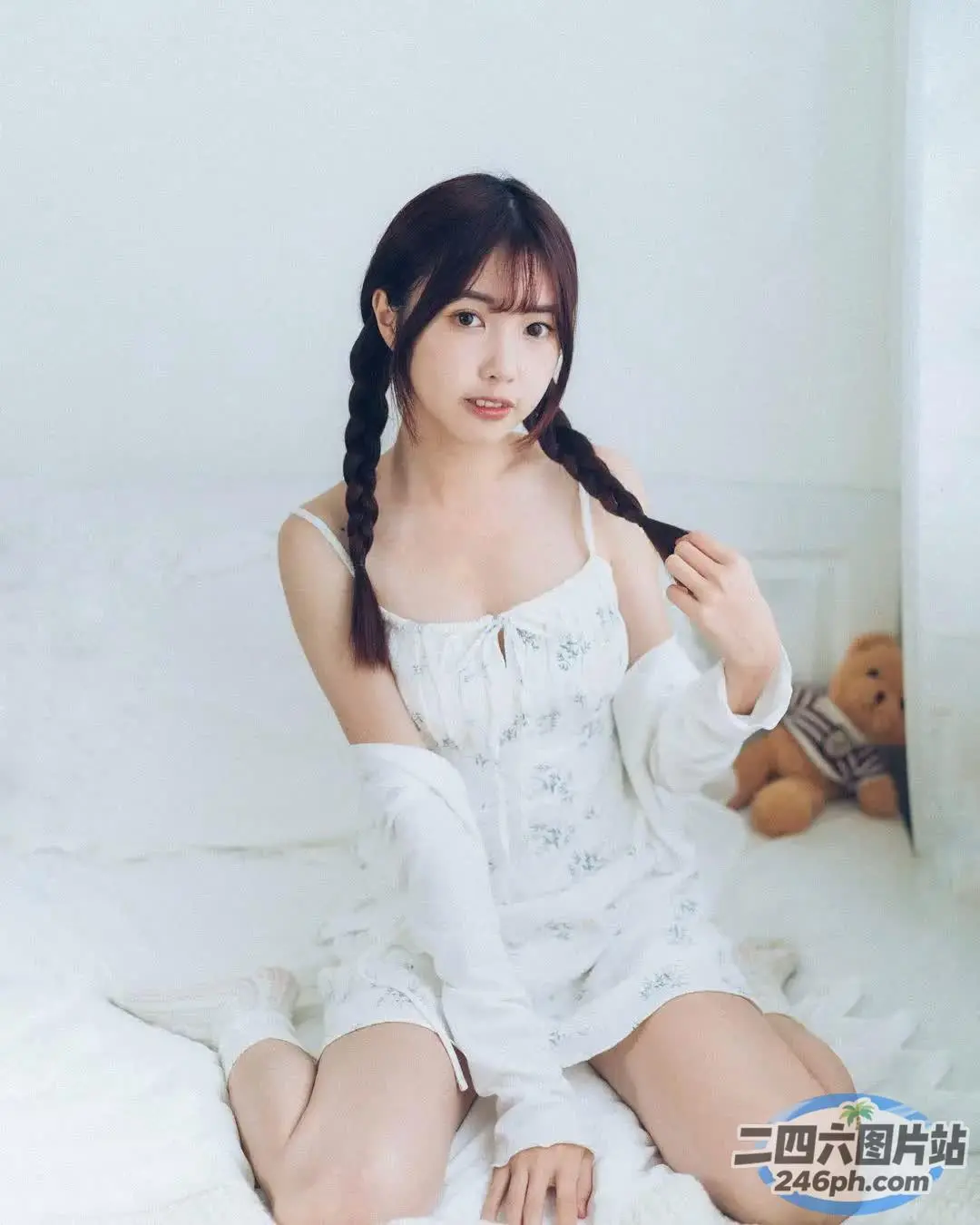 阿拉伯裔亚洲妇女和一只泰迪熊坐在床上