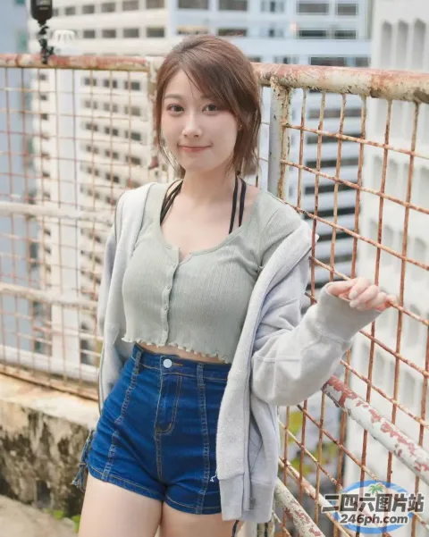 穿着牛仔短裙的亚洲女性靠在栅栏上