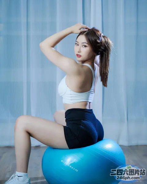 一名双腿交叉坐在蓝色球上的女子