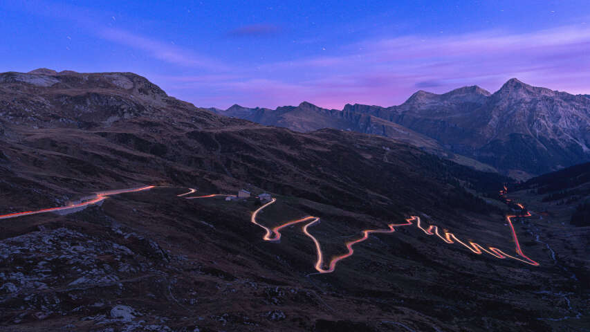 山峦蜿蜒的道路在前景中，蓝天蔚蓝