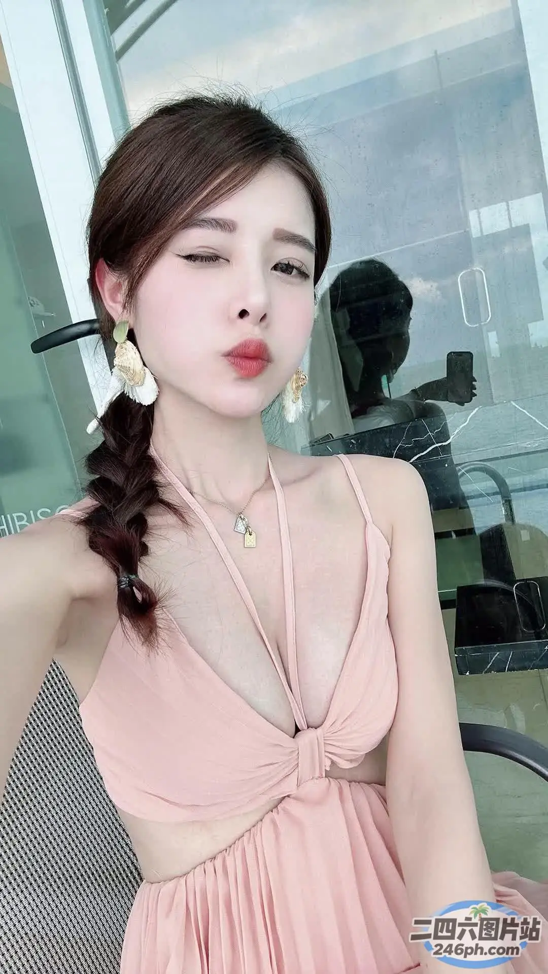 一位身穿粉红色连衣裙的女士坐在椅子上，手里拿着一把梳子