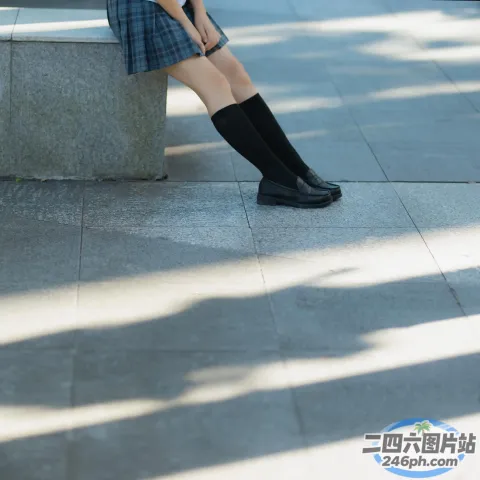 有个女人坐在长凳上，手里拿着手机