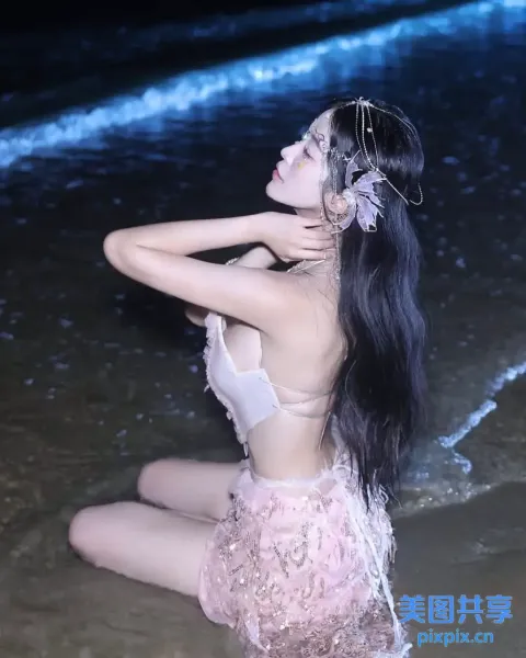 一个女人坐在海边海滩上的特写