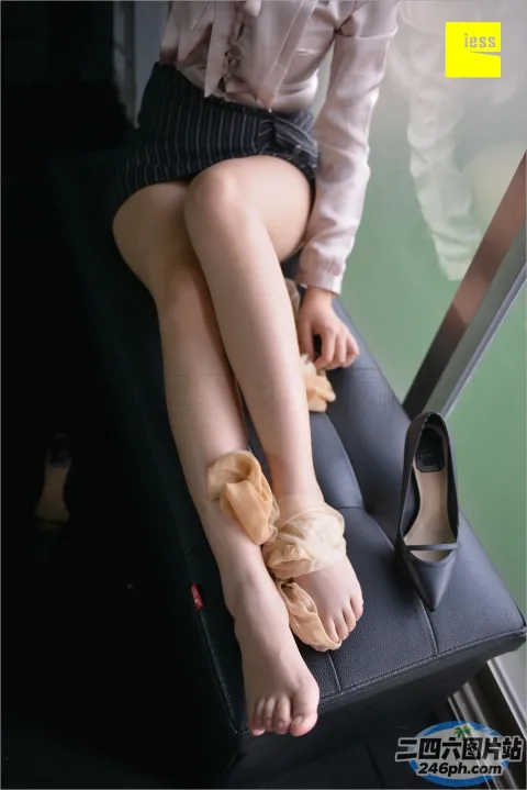 有一个女人坐在行李箱上，脚放在座位上