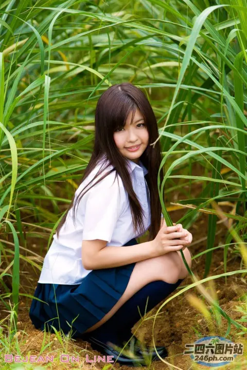 一个女孩跪在高草地上的特写