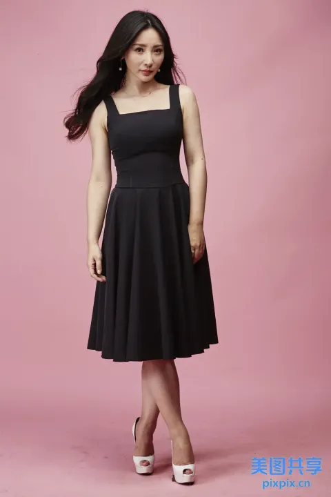 身穿黑色连衣裙的女子摆姿势拍照