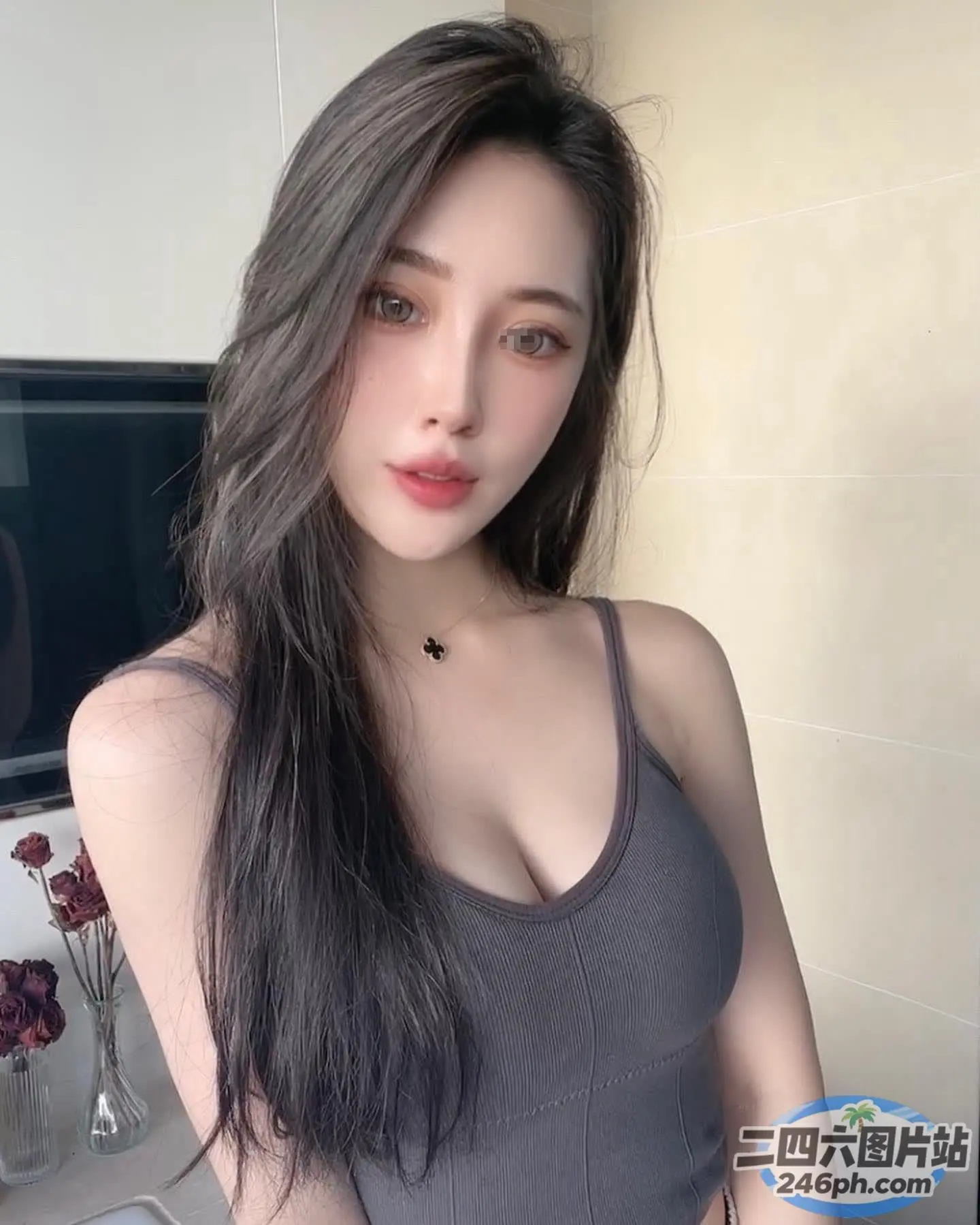 一个穿着灰色上衣的女人拿着一盒牙膏的特写