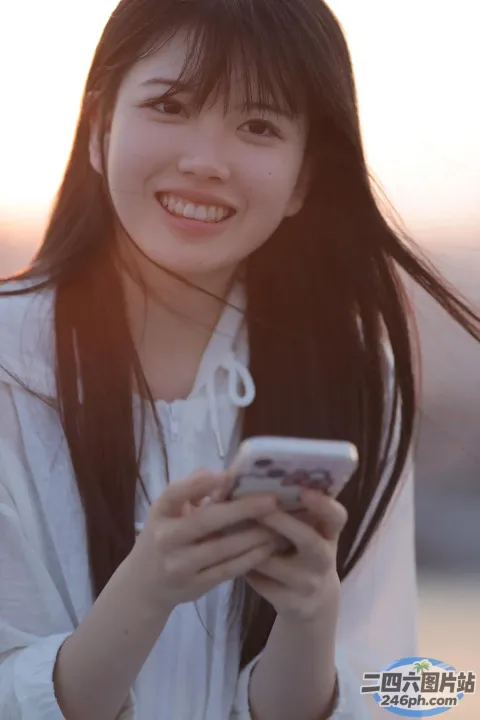 阿拉夫德亚裔女子站在海滩上看手机