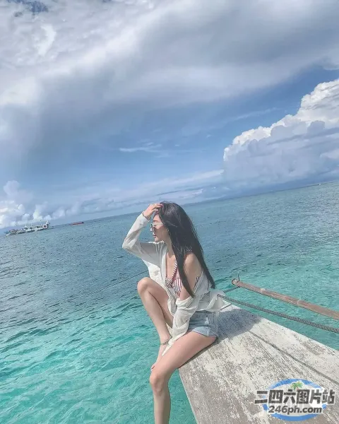 阿拉菲坐在码头上眺望大海
