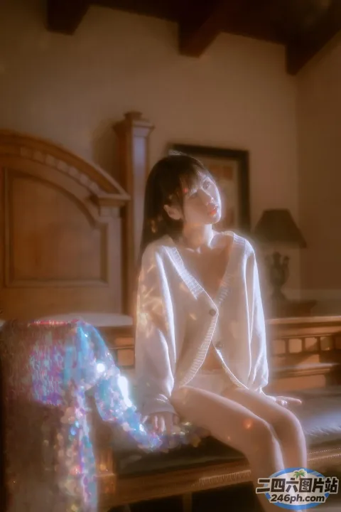 床上坐着一个穿着白色长袍的女人