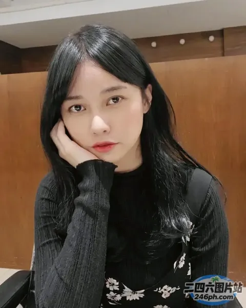 有个女人坐在一张桌子旁，桌上放着一盘食物