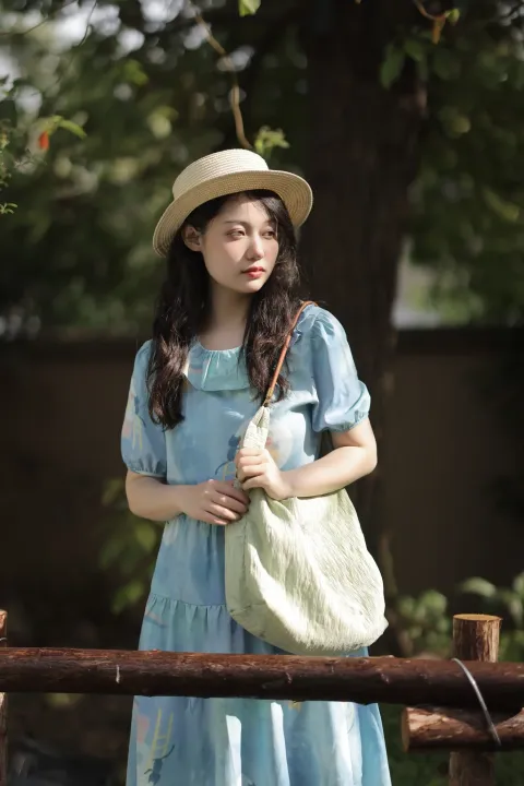 一个穿着蓝色连衣裙、戴着帽子的女人，手里拿着一个白色的包