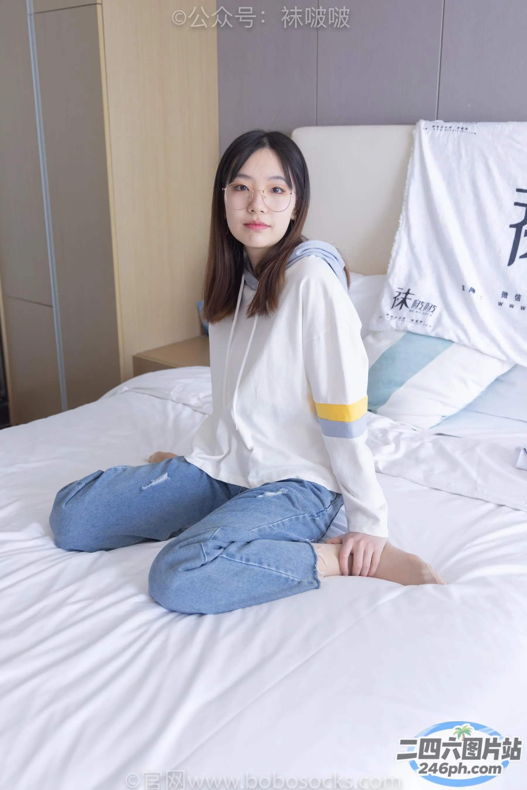 一个女人穿着白衬衫坐在床上的特写