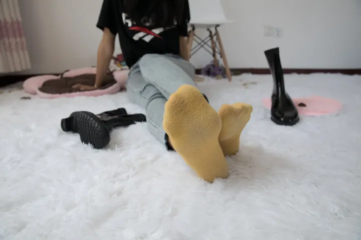 阿拉菲坐在白色地毯上，双脚抬起