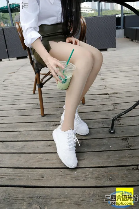 有个女人坐在椅子上，手里拿着一杯饮料
